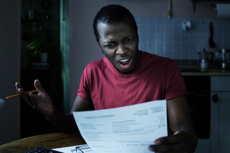 Homem frustrado e com raiva por notificação informando que teve o nome negativado indevidamente.